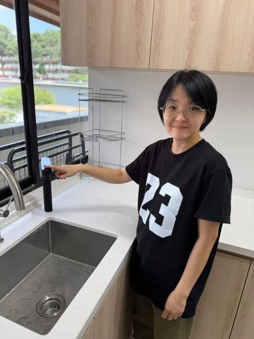 AquaLuxe customer standing beside the EliteTap tap in their kitchen